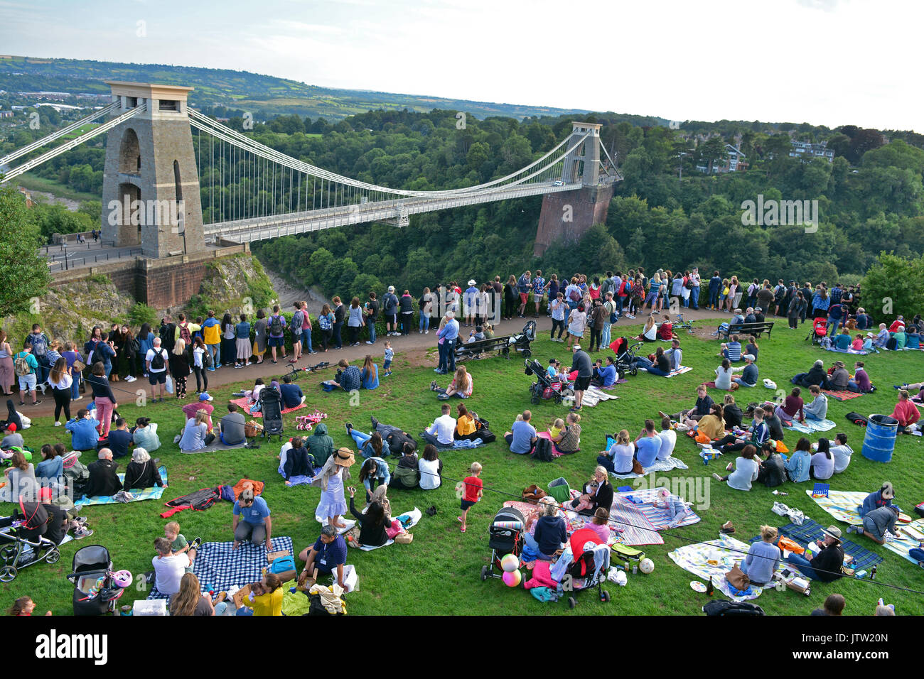 Bristol, UK. 10 Aug, 2017. Großbritannien Bristol. Tausende von Menschen sitzen auf dem Gras von der Informationsstelle Tower mit Blick auf den berühmten Clifton Suspension Bridge, in der Hoffnung, einen wunderbaren Blick auf die Ballons zu erhalten, wie Sie weg von Ashton Hof Immobilien am ersten Abend der Veranstaltung heben. Obligatorische Byline Credit: Robert Timoney/Alamy leben Nachrichten Stockfoto