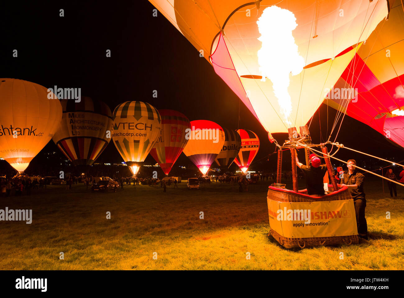 Heißluftballons, die in der Nacht leuchten im Bristol International Balloon Fiesta an Ashton Hof, Bristol, England. Stockfoto