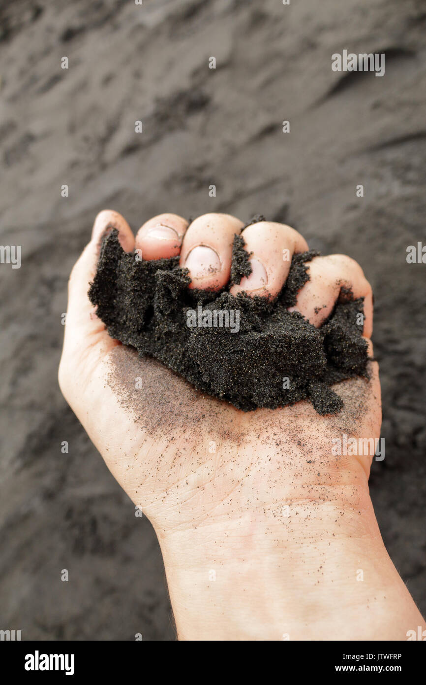 Eine Handvoll vulkanischen schwarzen Sand vom Strand Almaciga in Teneriffa, Kanarische Inseln Stockfoto