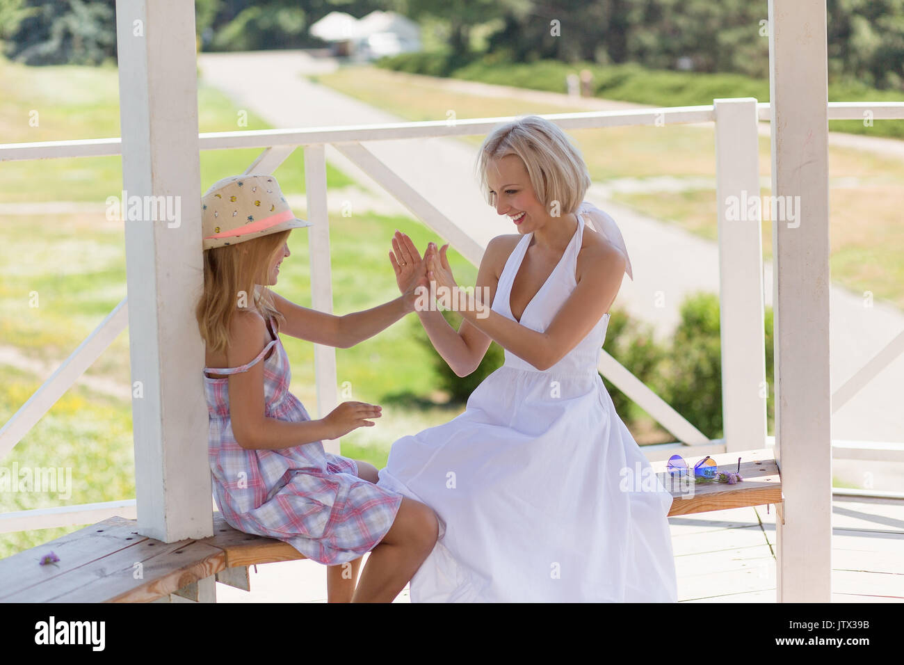 Schöne junge Mutter und Tochter spielen mit Händen. Stockfoto