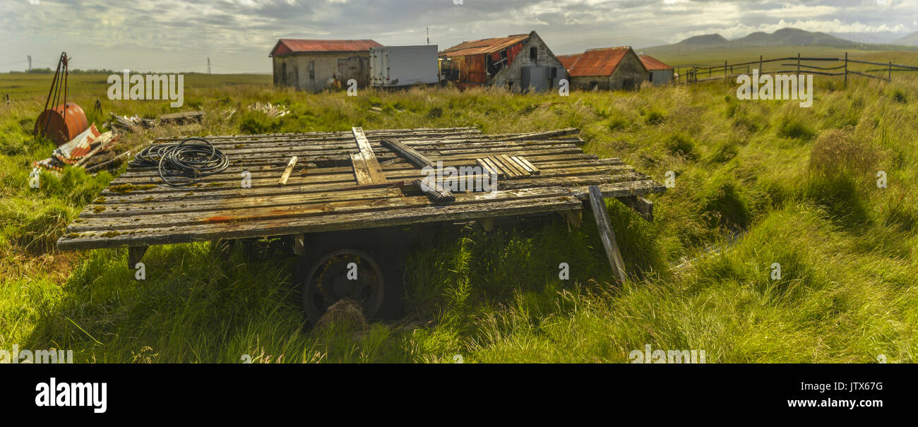 Panorama von einer Farm in der Nähe von Geysir in Island. Landwirtschaftliche Gebäude, Fahrzeuge und Maschinen liegen gebrochen und verlassen. Stockfoto