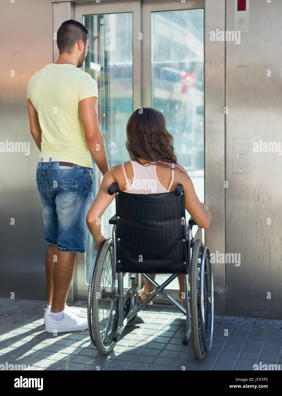 Schöner Mann helfen behinderten Freundin im Freien Fahrstuhl Stockfoto