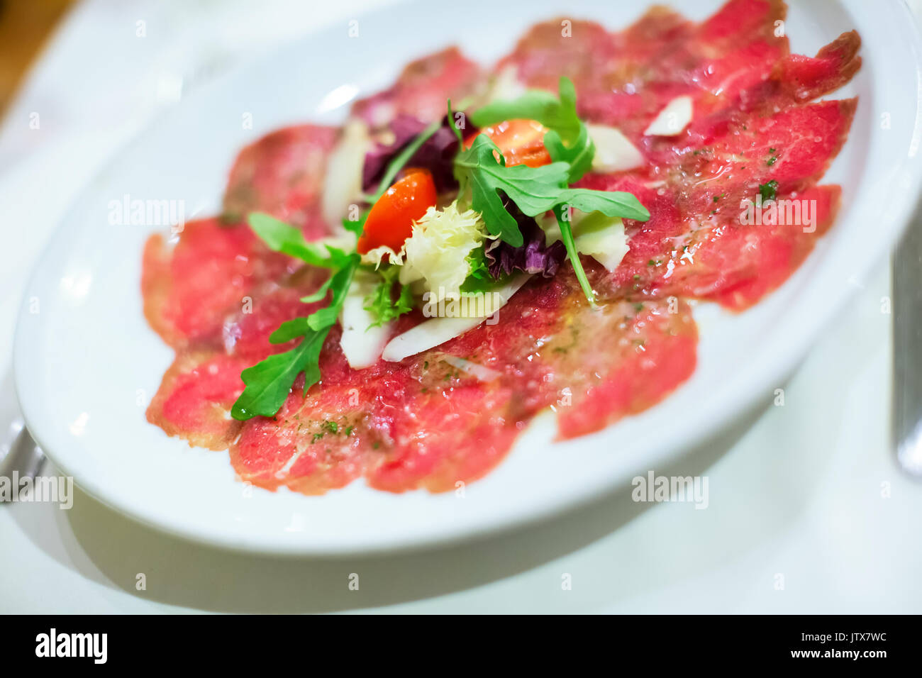 In dünne Scheiben geschnitten Vorspeise Fleisch Carpaccio mit Rucola Salat  serviert Stockfotografie - Alamy