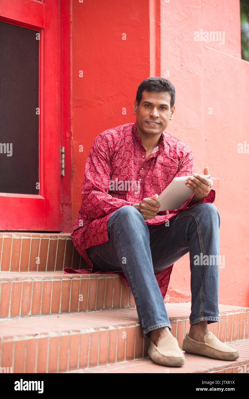 Gerne Inder mit Tablet-PC auf der Straße. Traditionelle indische Männer tragen eine kurta mit Tablet Computer außerhalb. Stockfoto