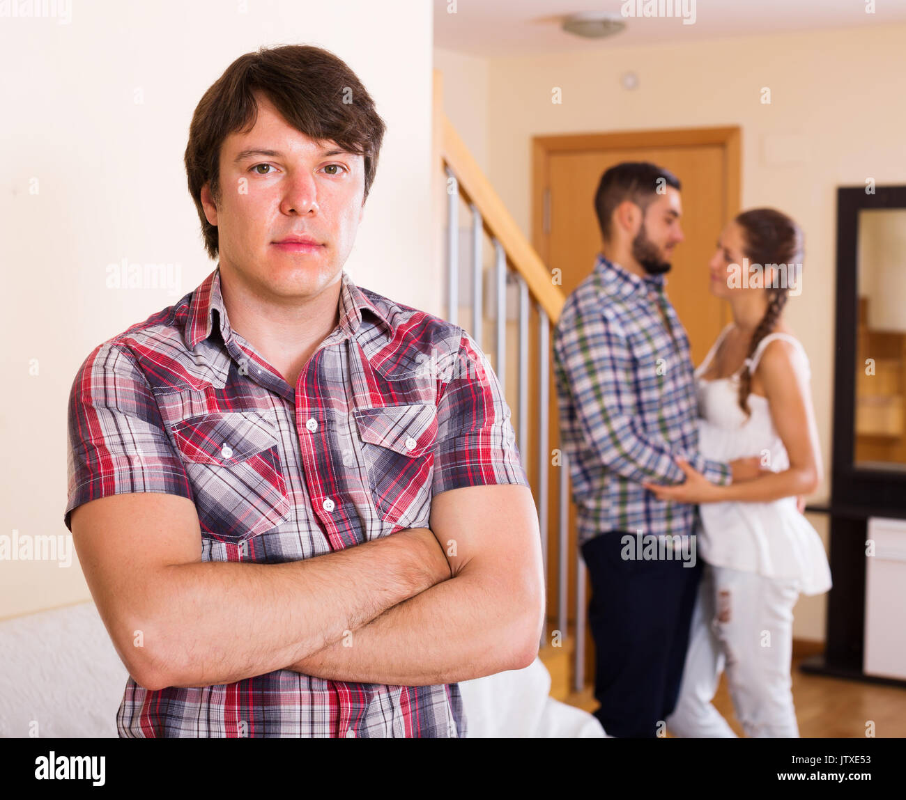 Eifersüchtiger Ehemann beobachten Ehepartner flirtet mit Freund zu Hause Stockfoto