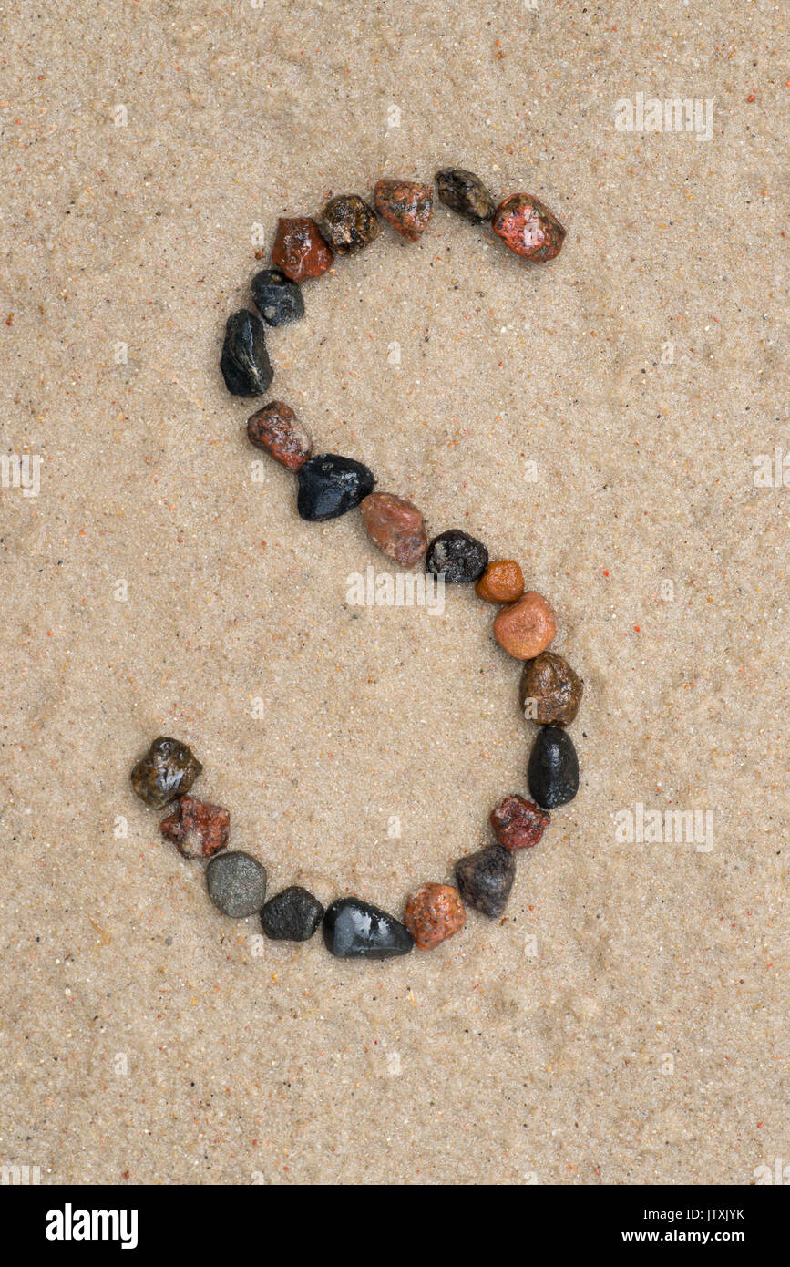 Kiesel s Schreiben auf Sand Hintergrund Stockfoto