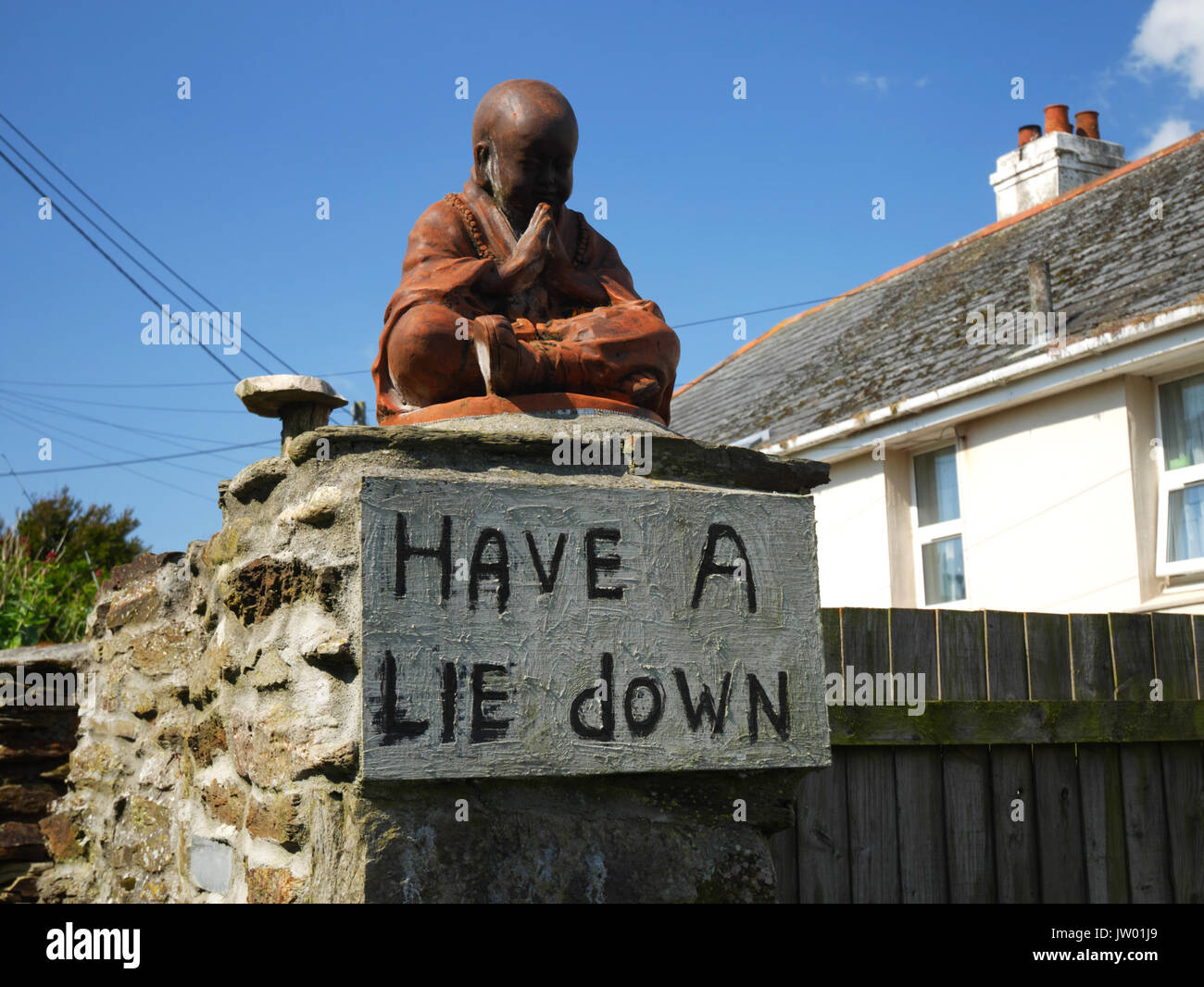 "Hinlegen" Schild und Buddha Statue bei Polruan, Cornwall. Stockfoto
