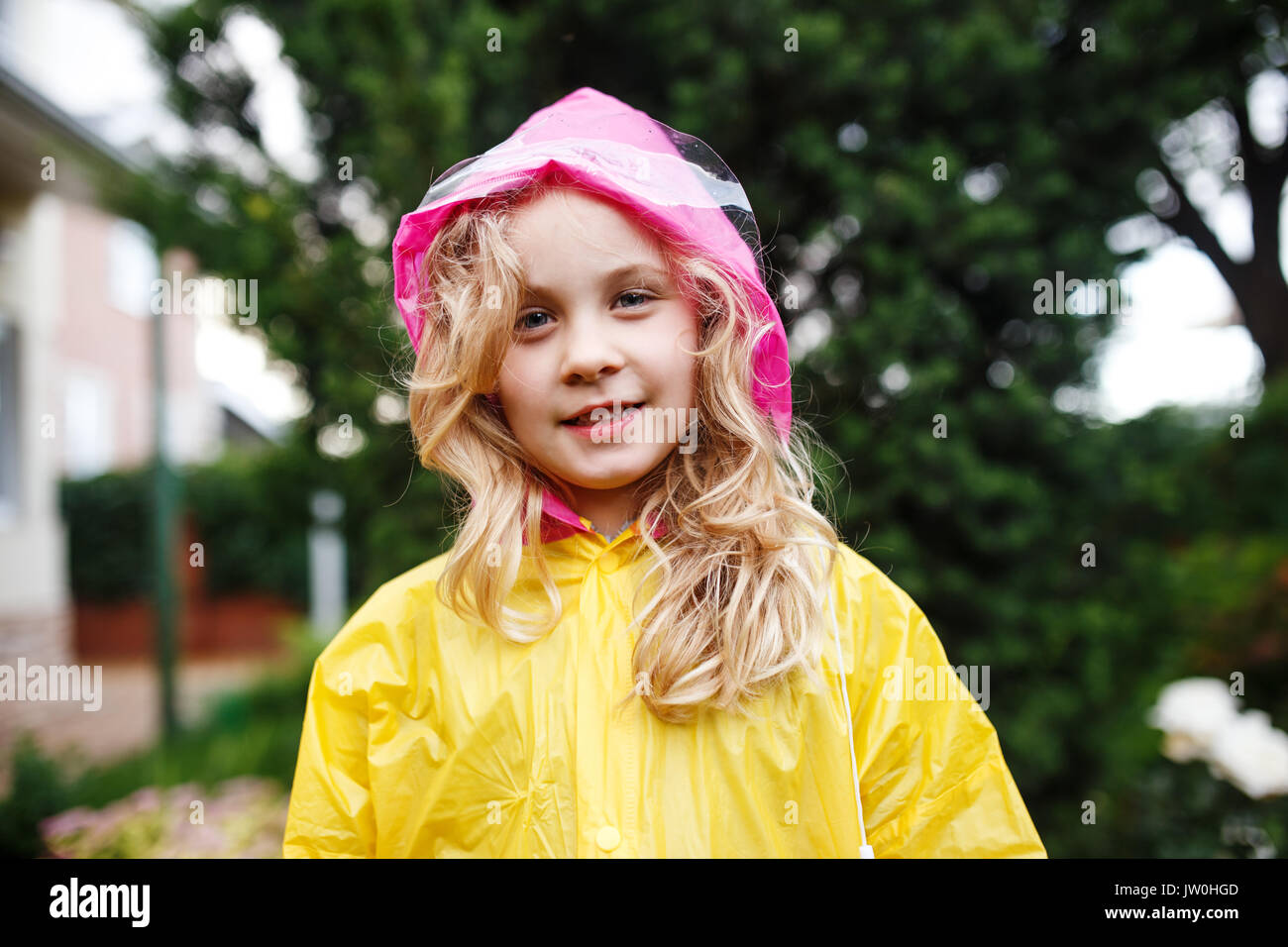 Glückliches Kind Mädchen im gelben Regenmantel. Stockfoto