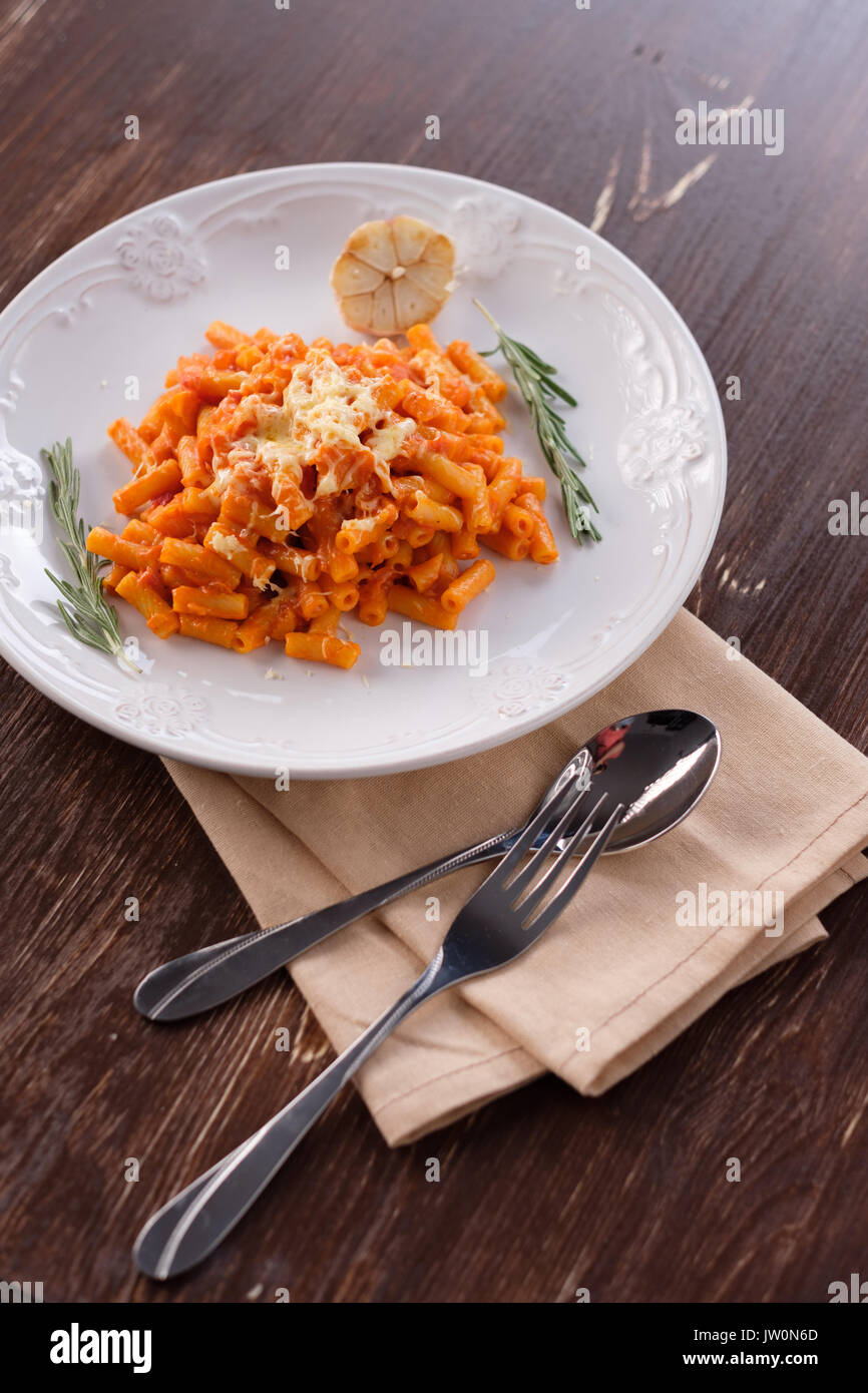 Italienische Pasta mit Tomaten, Käse und Knoblauch. close-up auf einem Teller mit geschmolzenem Käse. Stockfoto