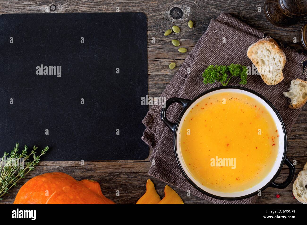 Kürbis creme Suppe in der Schüssel auf rustikalen Holztisch. Ansicht von oben, kopieren Platz für Text Stockfoto