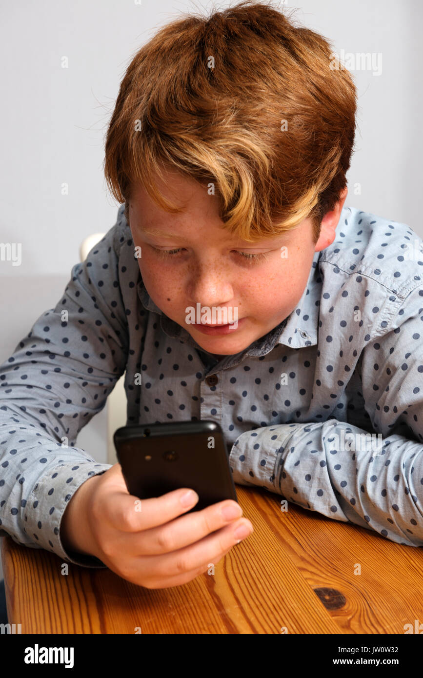 11-jähriger Junge mit Smartphone social media für den Zugriff auf Stockfoto