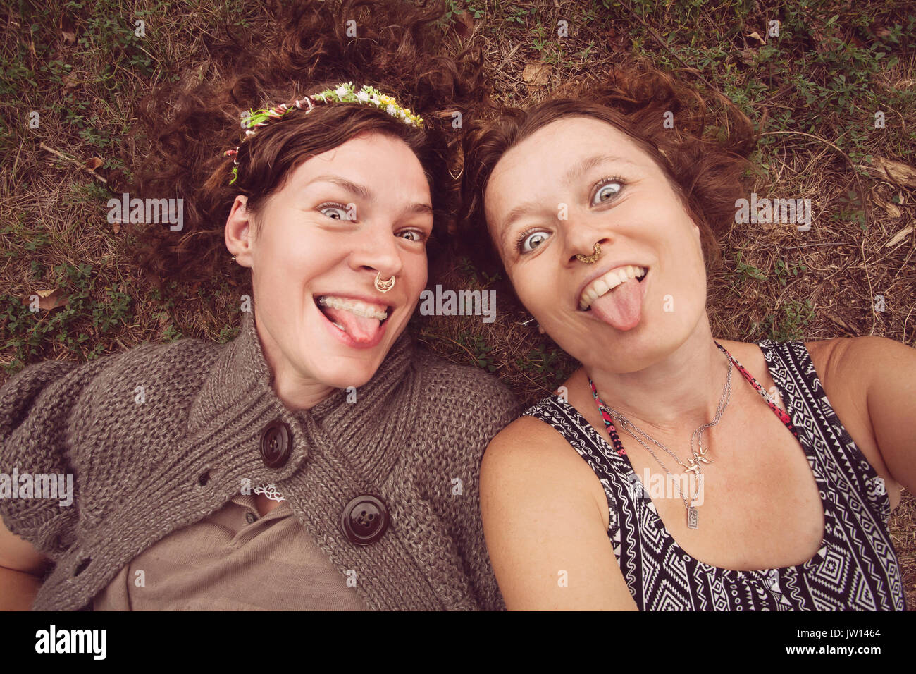 Zwei lustige Mädchen zeigen ihre Zungen in der Natur Stockfoto