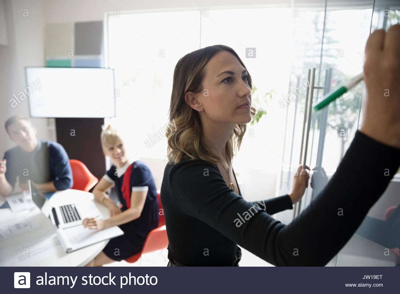 Mit trockenem löschen Marker whiteboard im Konferenzraum Sitzung arbeiten Geschäftsfrau Stockfoto