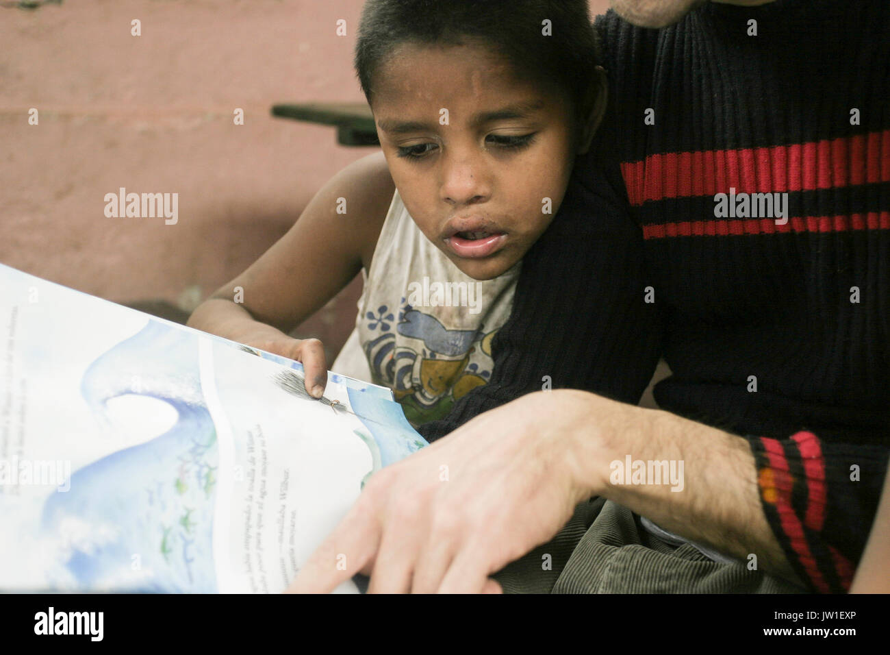 Ein freiwilliger eine Geschichte liest, ein armer Junge, Tucuman, Argentinien, Südamerika Stockfoto