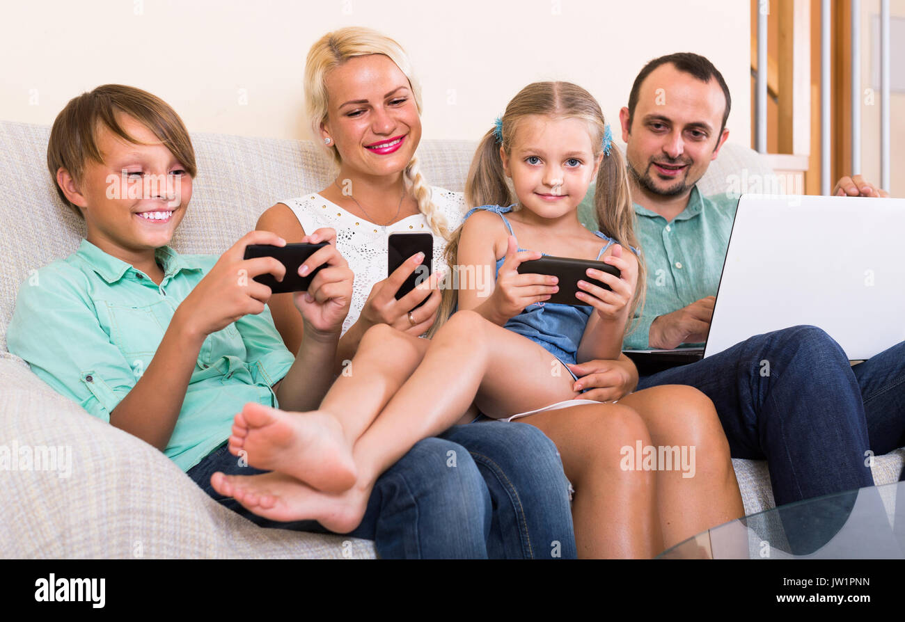 Portrait von Happy europäischen Familie spielen mit Gadgets zu Hause Stockfoto