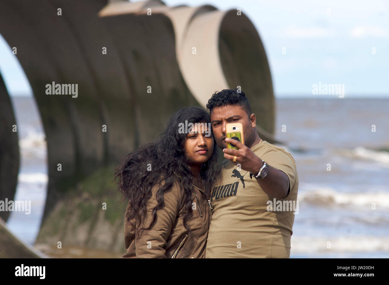 Asiatische Paar unter selfie vor Mary's Shell Skulptur am Strand von Cleveleys, Lancashire, Großbritannien Stockfoto