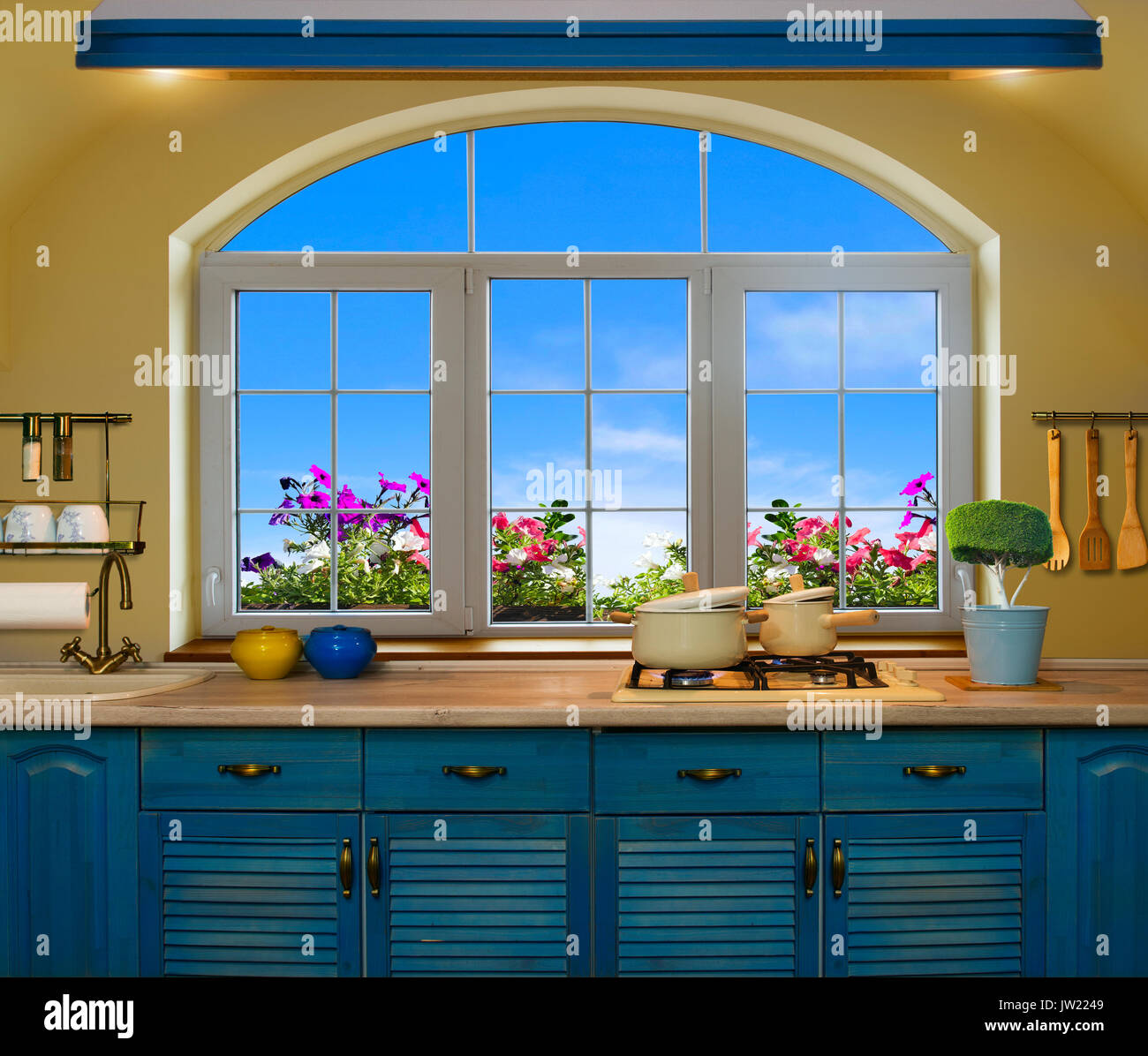Innenraum blau Küche. Vorbereitung Mittagessen zu Hause auf dem Herd mit einem Blick aus dem Fenster auf die grünen Wiesen und Felder Stockfoto