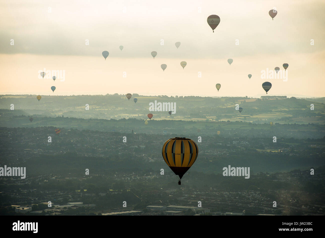Heißluftballone fliegen über der Stadt Bristol während der ersten Aufstieg, wo Ballons aus aller Welt bei Ashton Hof, Bristol, an der Bristol International Balloon Fiesta zu nehmen. Stockfoto