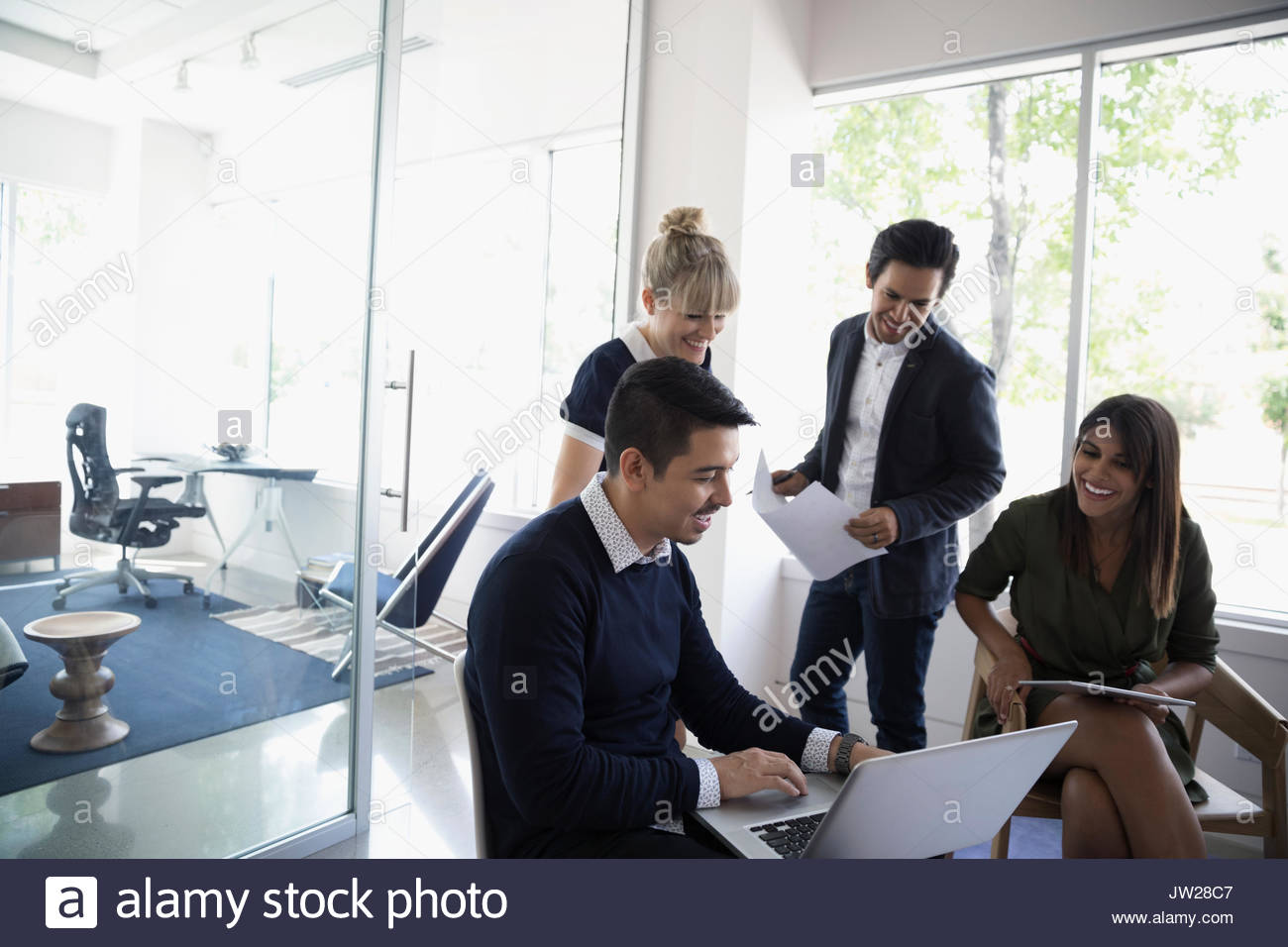 Geschäftsleute, die mit Laptop im Büro treffen Stockfoto