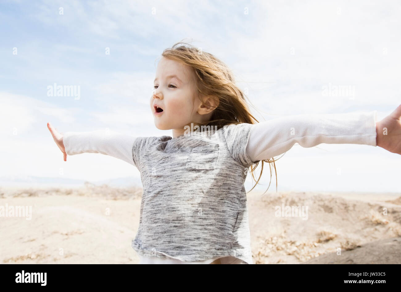 Portrait von kleinen Mädchen (4-5) mit ausgestreckten Armen und offenen Mund im Feld Stockfoto
