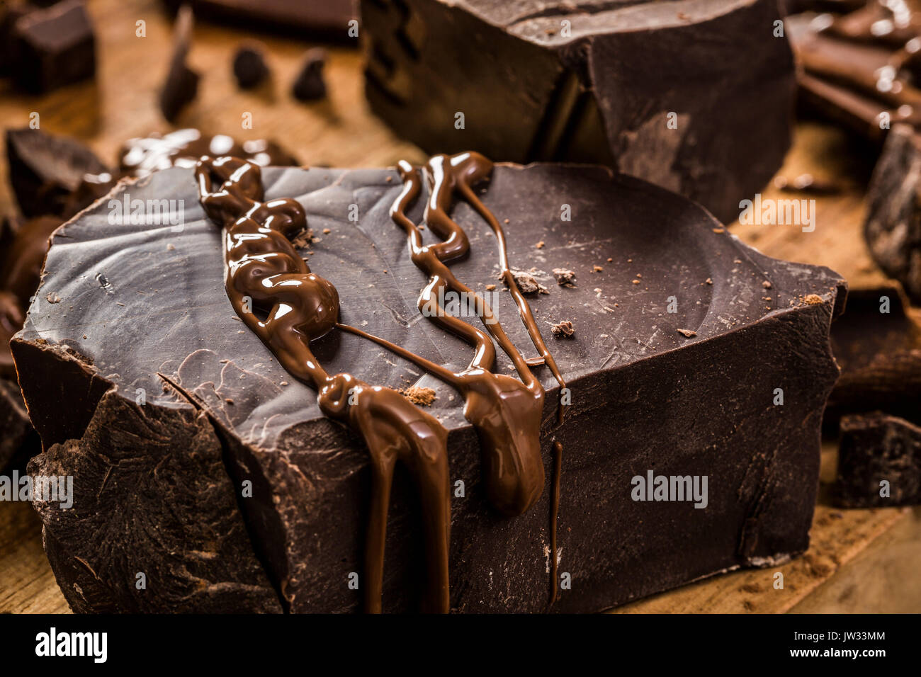 Geschmolzene Schokolade auf große dunkle Schokolade Klumpen Stockfoto