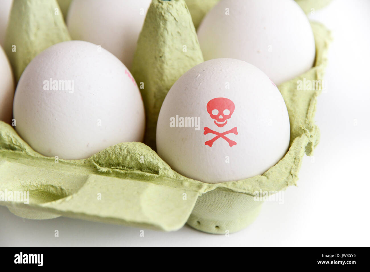 Eier in der Papier-Paket mit einem Ei mit einem roten giftig Gefahr symbol Schädel und Knochen bemalt. Bild Konzept für Lebensmittel Verunreinigungen und ei Skandal. Stockfoto