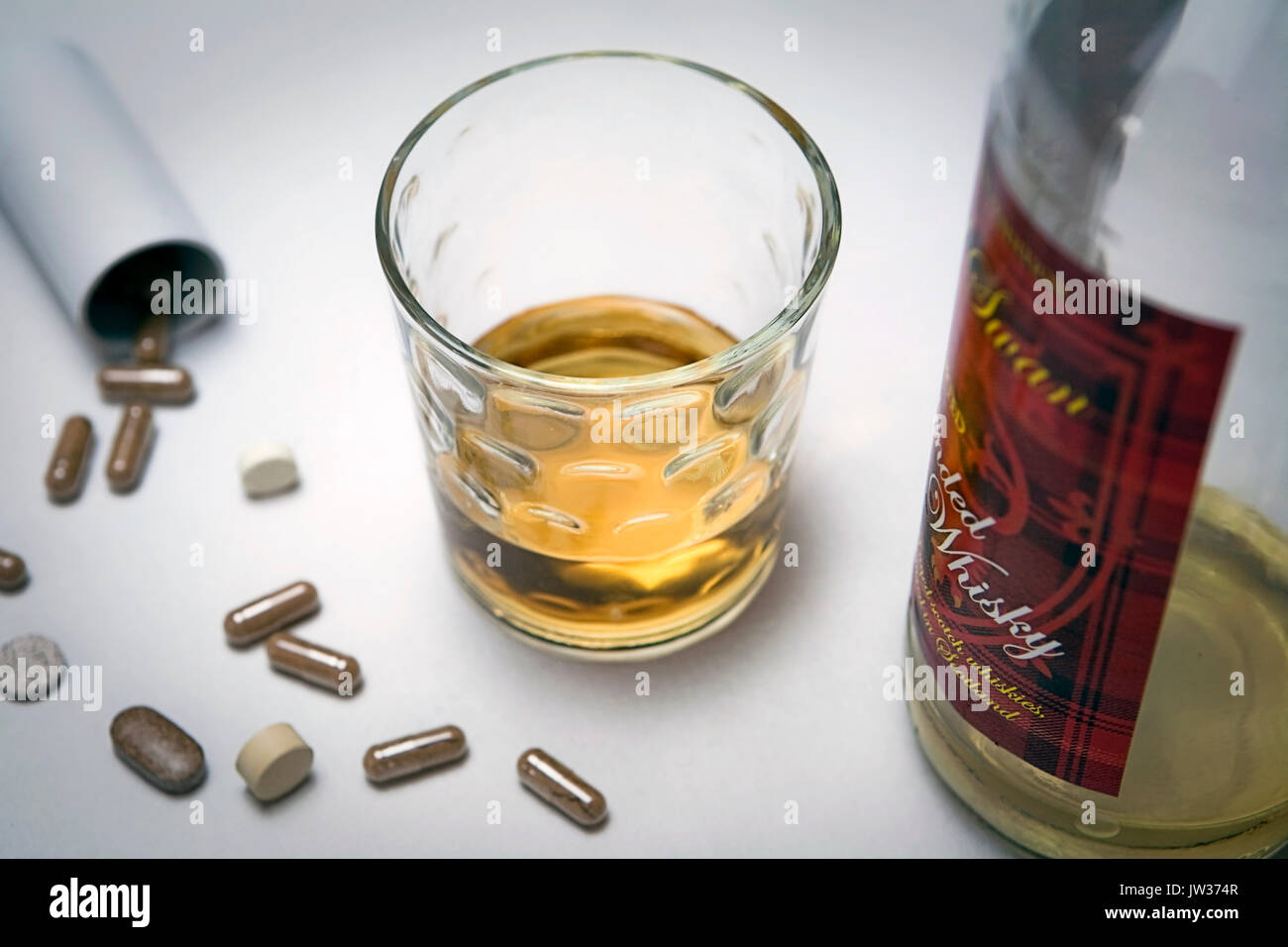 Whiskey Glas mit Pillen, Konzept des Alkoholismus Stockfoto