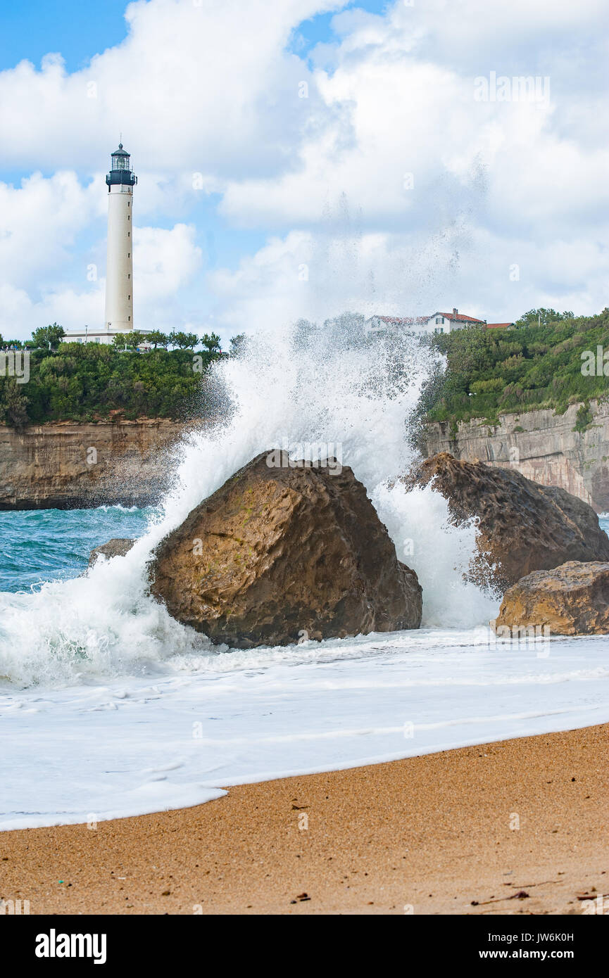 Weißen Leuchtturm auf einem Hintergrund raue See mit massiven Wellen brechen in riesigen Felsen Stockfoto