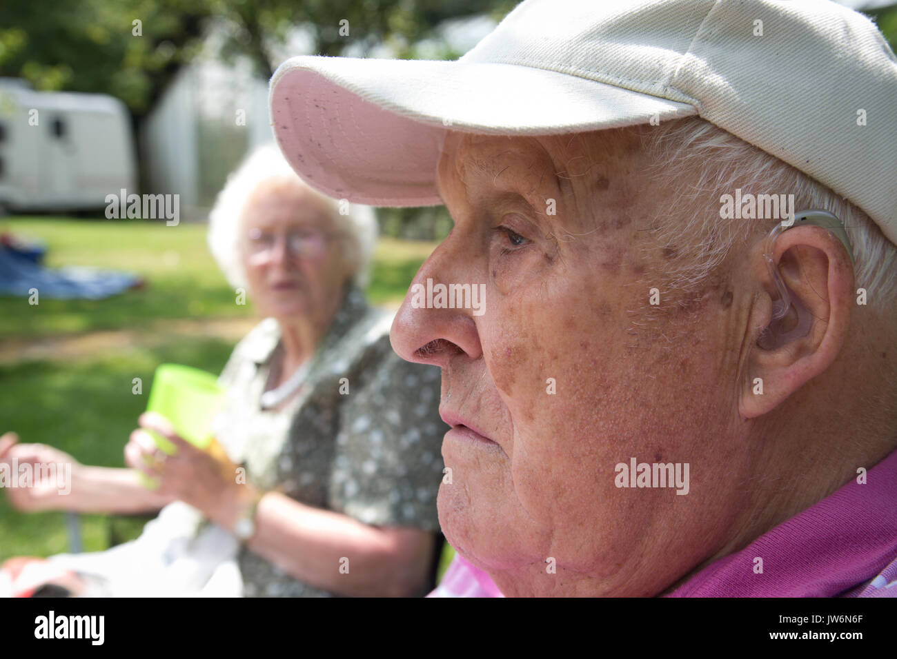 Älterer Mann mit Hörgerät, im Freien, England, Großbritannien Stockfoto