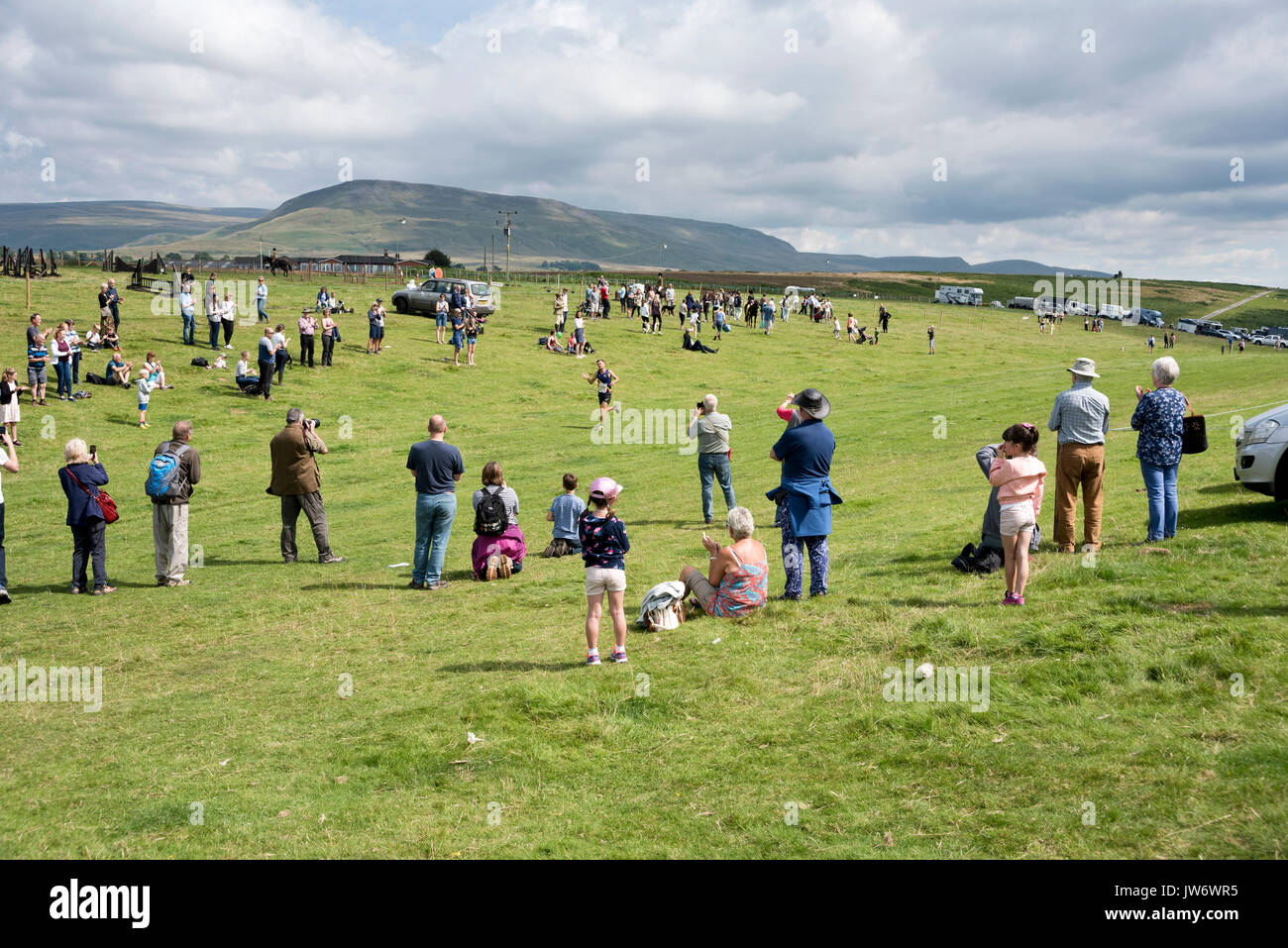 Die fiel Sieger kreuzt die Linie zu Applaus im Publikum bei der jährlichen Appleby zeigen, Cumbria, Großbritannien, 10. August 2017. Die Läufer rennen über Murton Hecht. Stockfoto