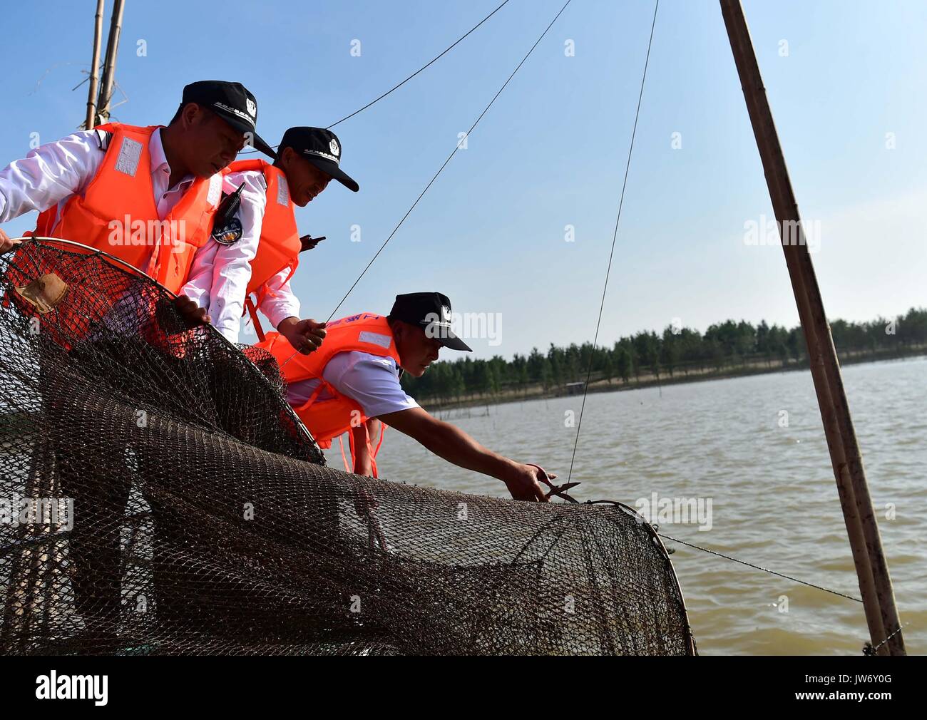 (170811) - ANQING, Aug 11, 2017 (Xinhua) - Aux Streifenpolizisten prüfen auf einem Boot in der finless porpoise Naturschutzgebiet in Anqing der ostchinesischen Provinz Anhui, 10.08.2017. Eine Patrouille der Feuerwehr, darunter 6 sind ehemalige Fischer, ihre Mission im Juni 2017 begann der Schutz der 60 finless Schweinswale entlang der 60 Kilometer langen Abschnitt der Yangtze Fluss in der Provinz. Telefon Anwendung ist in ihrer Routine Missionen eingesetzt zu verfolgen und die Delfine beobachten - wie die Säugetier leben, notwendigen Schutz bieten und die Schadstoff- und illegale Fischerei in der Reserve zu überwachen. (Xinhua / Liu Junxi) (Cl Stockfoto