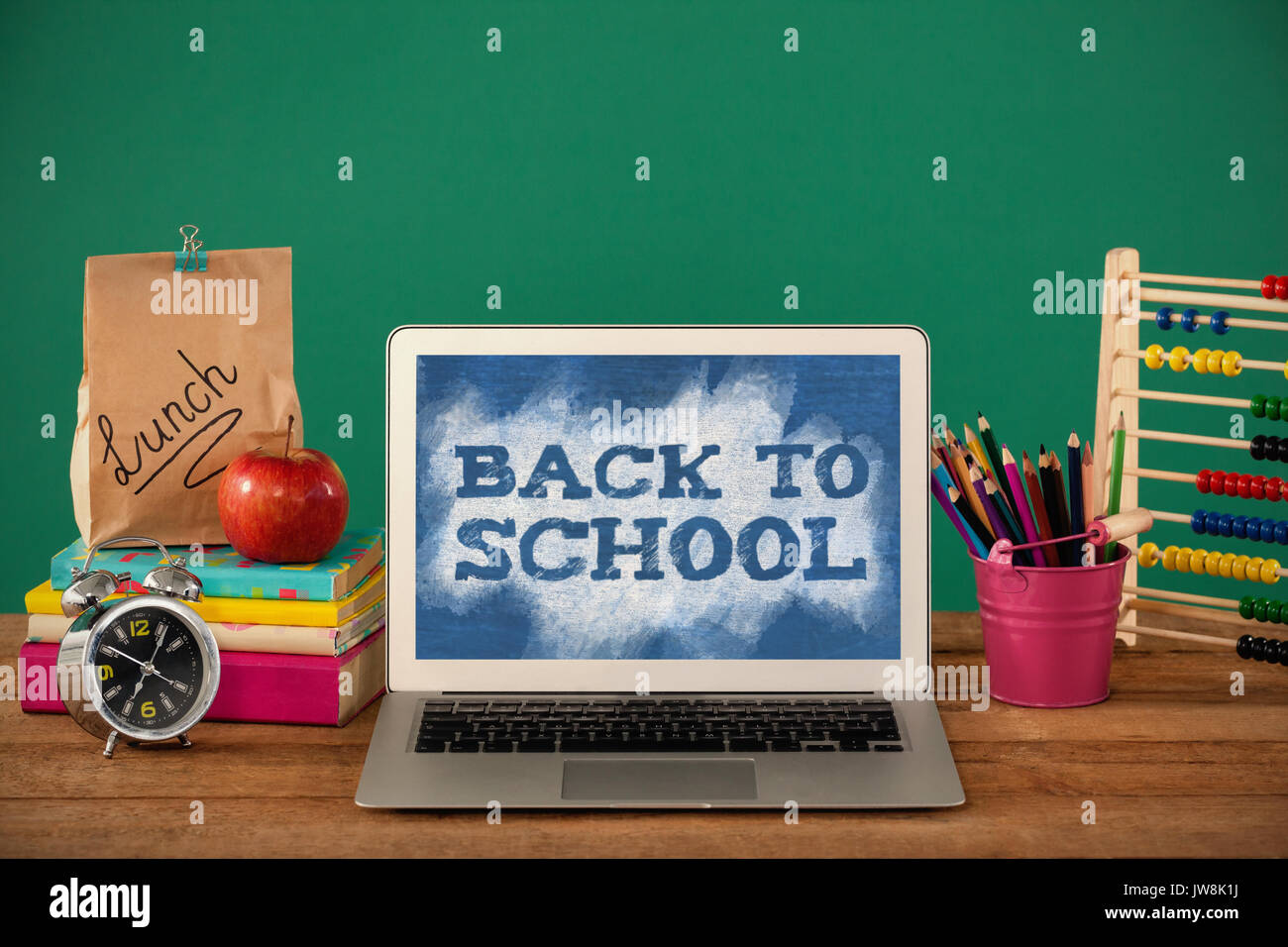 Zurück zum text Schule auf Grün und Blau splash gegen die Schule liefert mit Laptop auf hölzernen Tisch Stockfoto