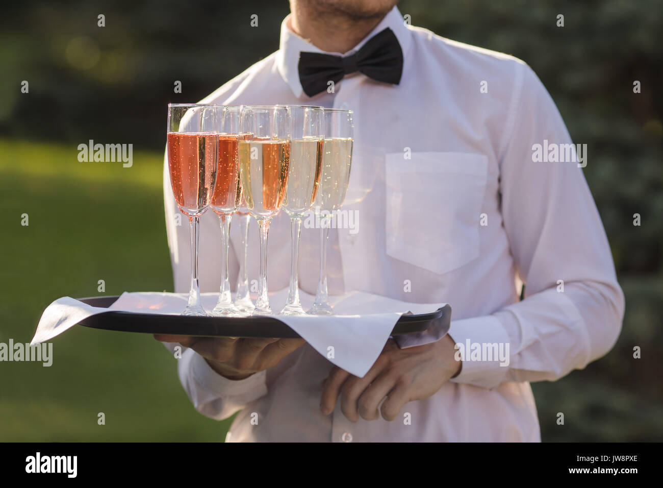Kellner Champagner auf einem Tablett serviert Stockfoto
