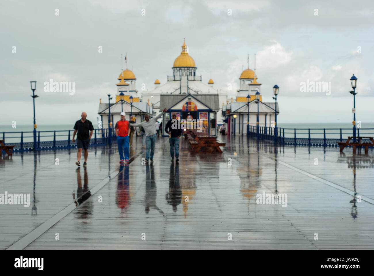Eine Serie von Fotografien auf Eastbourne Pier, durch Sonne und Regen. In einem typischen britischen Sommertag mit Farben, Reflexionen und Menschen. Stockfoto
