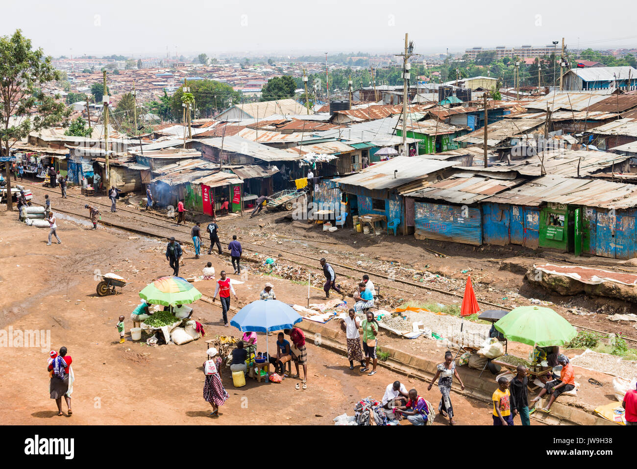 Slum Kibera mit Einwohnern und Hütten durch die Bahnlinie, Nairobi, Kenia Stockfoto