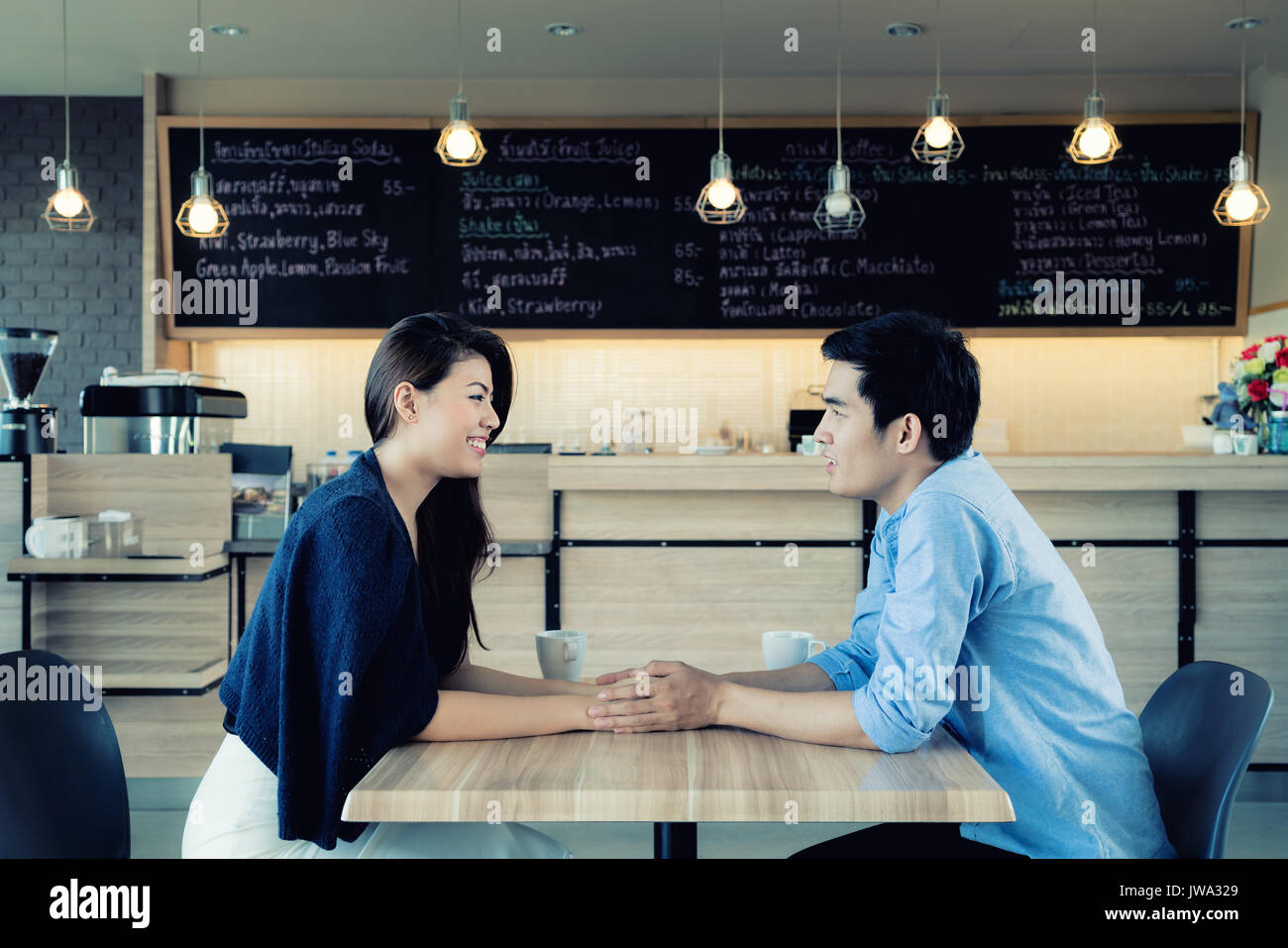 Partnersuche in einem Cafe. Schöne asiatische Liebhaber Paar sitzt in einem Café in Kaffee und Unterhaltung genießen. Liebe und Romantik. Stockfoto