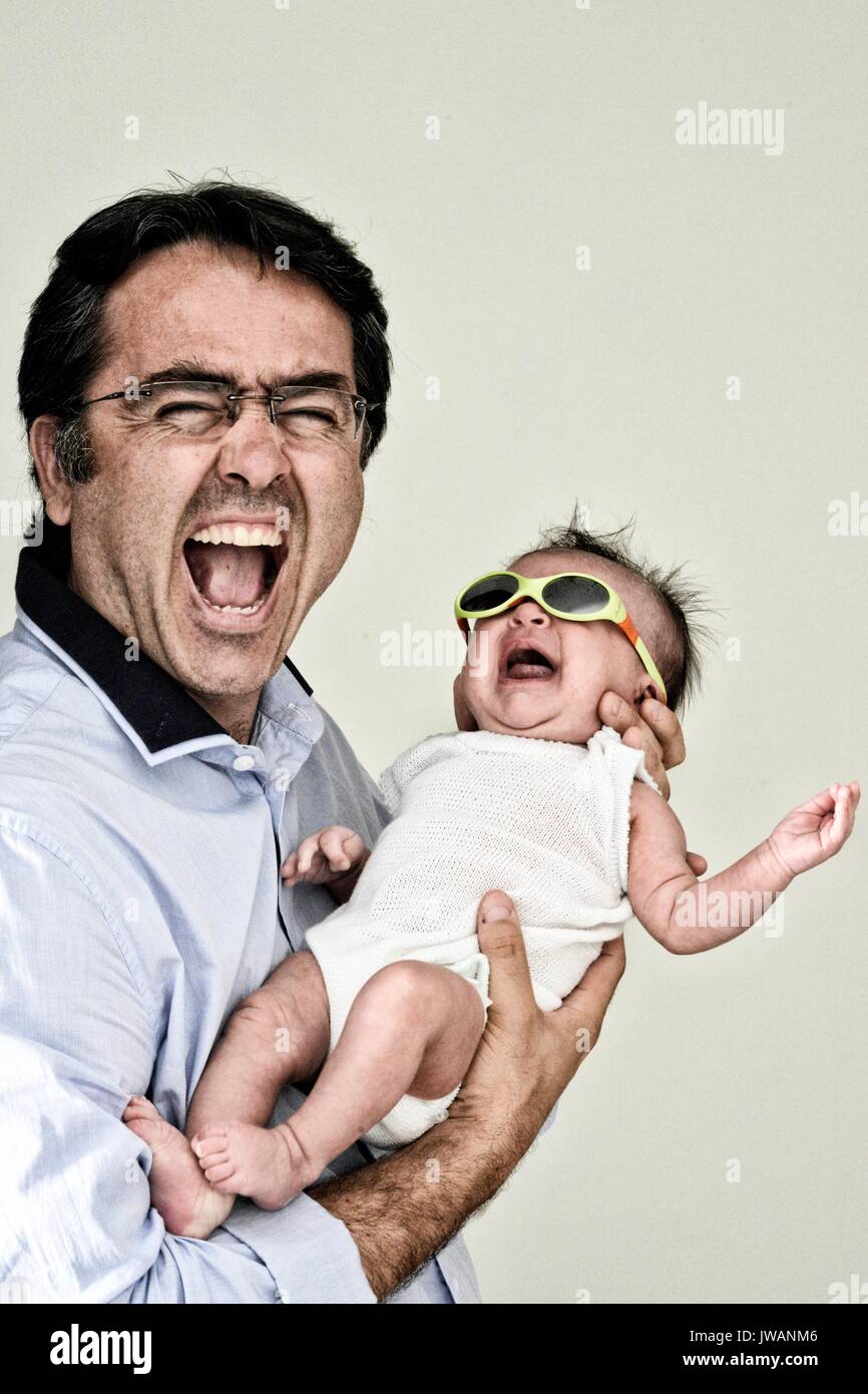 Ein Vater lacht mit seinen fünf Wochen alten Baby girl. Stockfoto