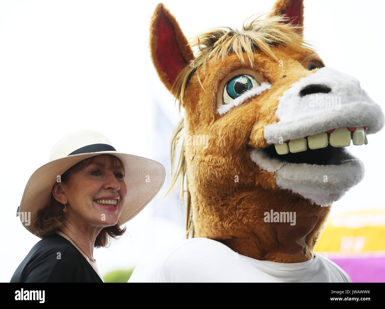 Eine Frau posiert für ein Foto mit einem Pferd Maskottchen an der Dublin Horse Show im RDS in Dublin. Stockfoto