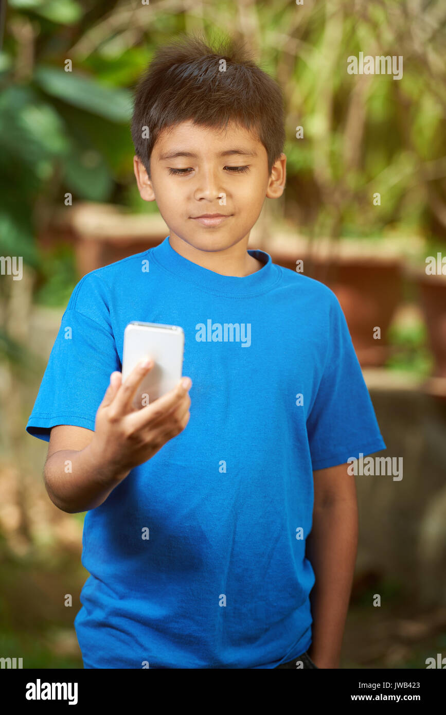 Kleiner Junge Blick in Smartphone Holding vor ihm Stockfoto