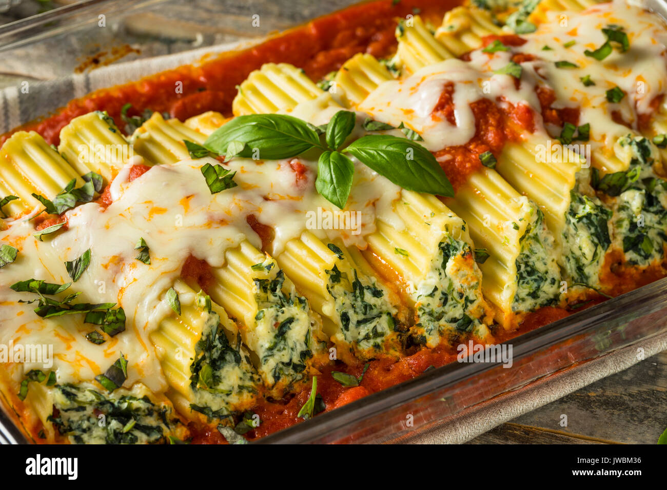 Hausgemachte gefüllt mit Ricotta und Spinat Manicotti mit Basilikum Stockfoto