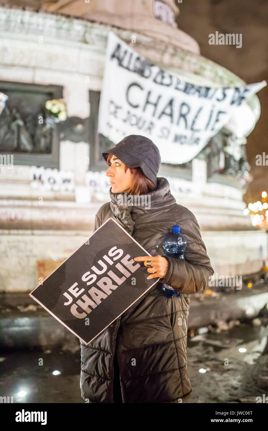 Eine Frau mit einem Schild je suis Charlie, der sich vor der Statue Place de la Republique. Hommage an die Opfer von Charlie Hebdo Tötung in Stockfoto