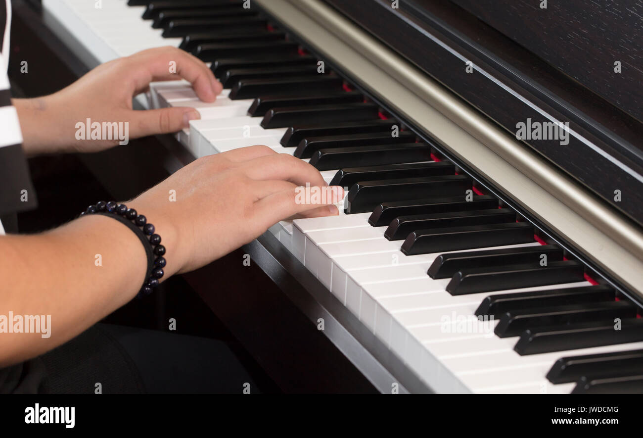 Junge person spielen und üben das Klavier auf den weißen und schwarzen Tasten Stockfoto