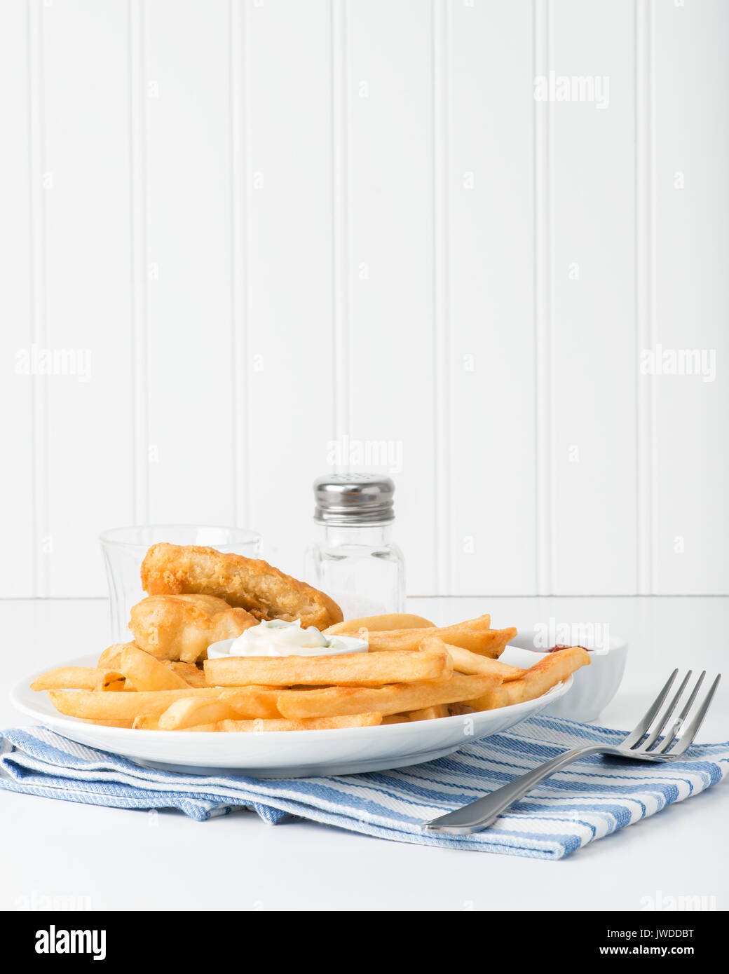 Frittierte Kartoffeln sind die Schwerpunkte der Platte mit Fisch und Chips. Stockfoto