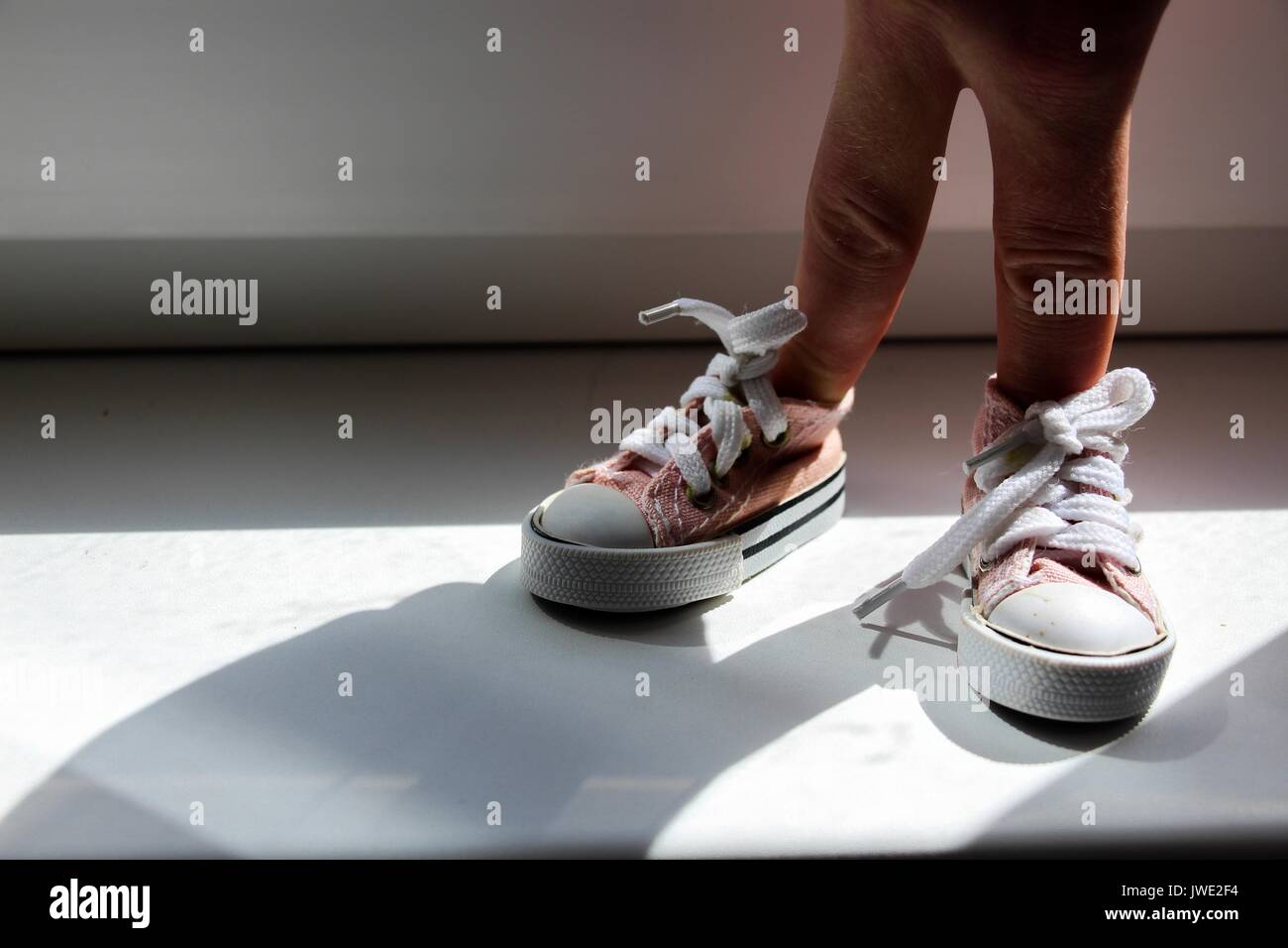 Einstellung - die Finger in Turnschuhen gekleidet sind. Stehende Position. Stockfoto