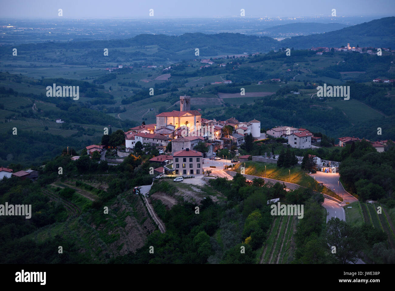 Mittelalterliche Dorf Smartno Brda Slowenien in der Morgendämmerung in der görzer Hügel mit St. Martin Kirche, Medana Dorf und italienische Stadt leuchtet Stockfoto