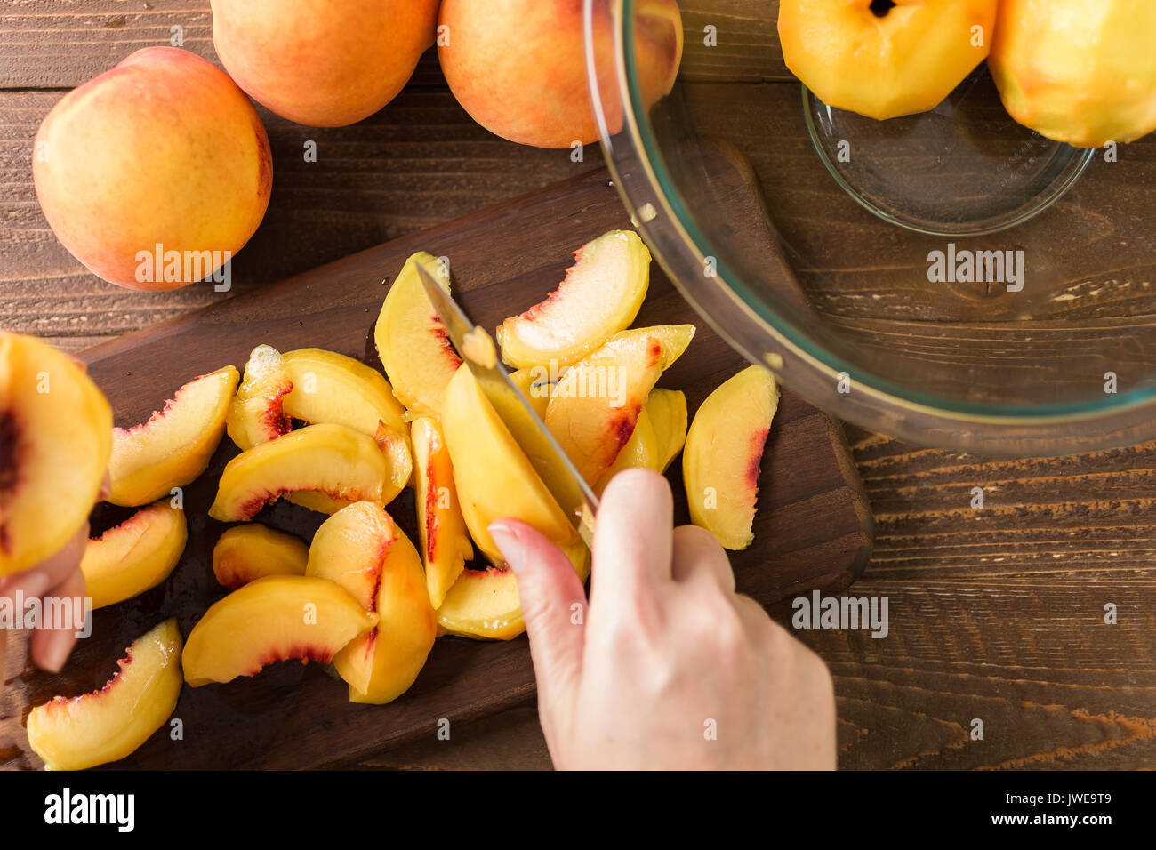 Slicing Bio Pfirsiche für Peach cobbler. Stockfoto
