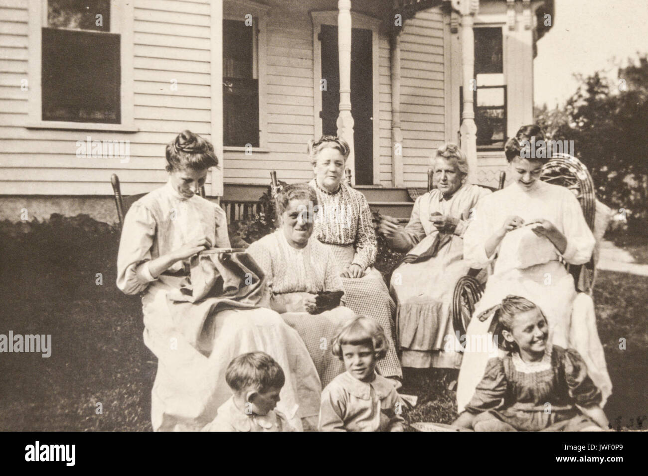 Frauen nähen Needlepoint mit kleinen Kindern im Freien in Minnesota, USA 1907-1908 Spaß Stockfoto