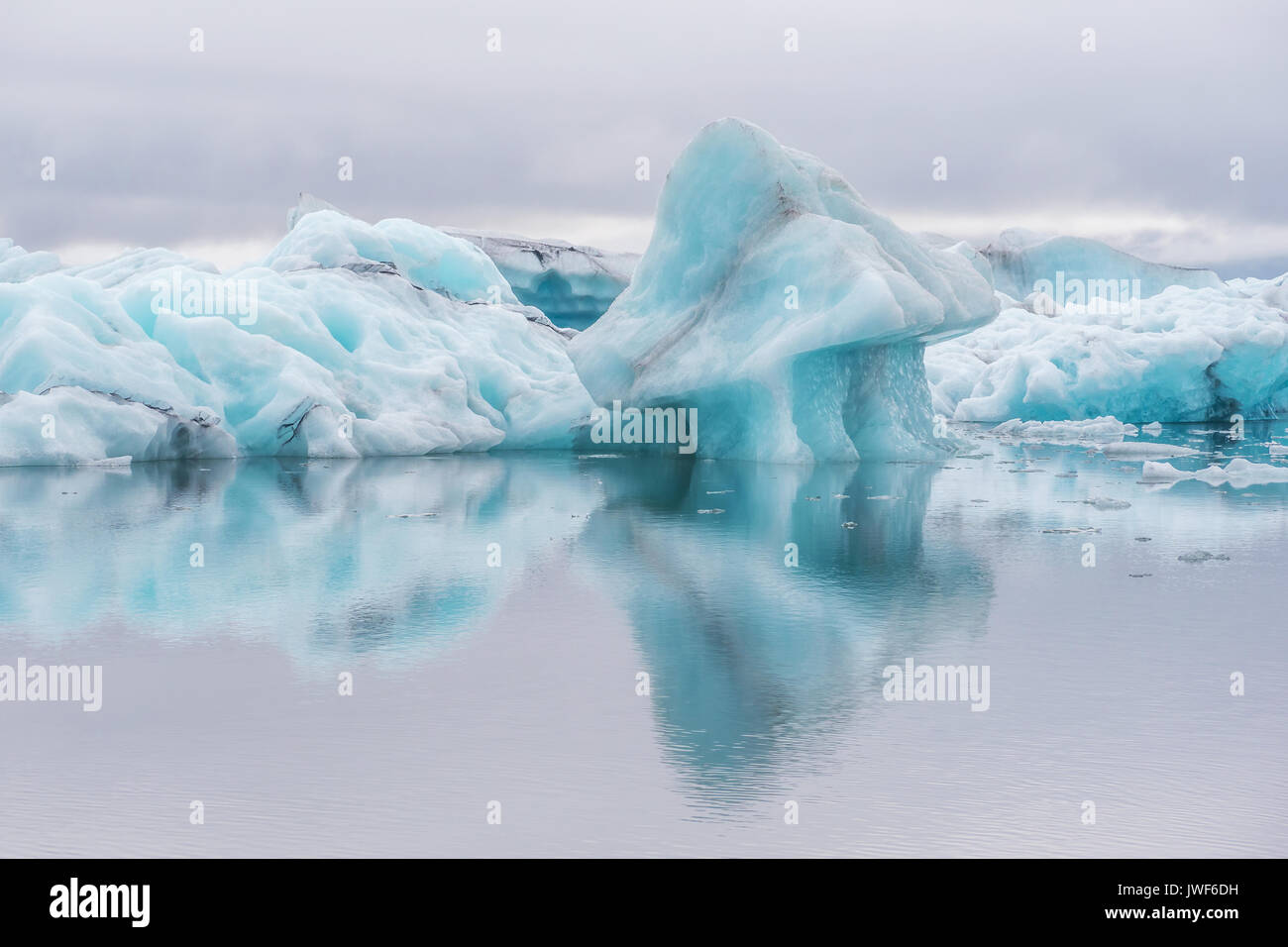 Blaue Eisberge auf ruhigem Wasser mit Reflexionen in Gletscherlagune Jokulsarlon. Island. Stockfoto
