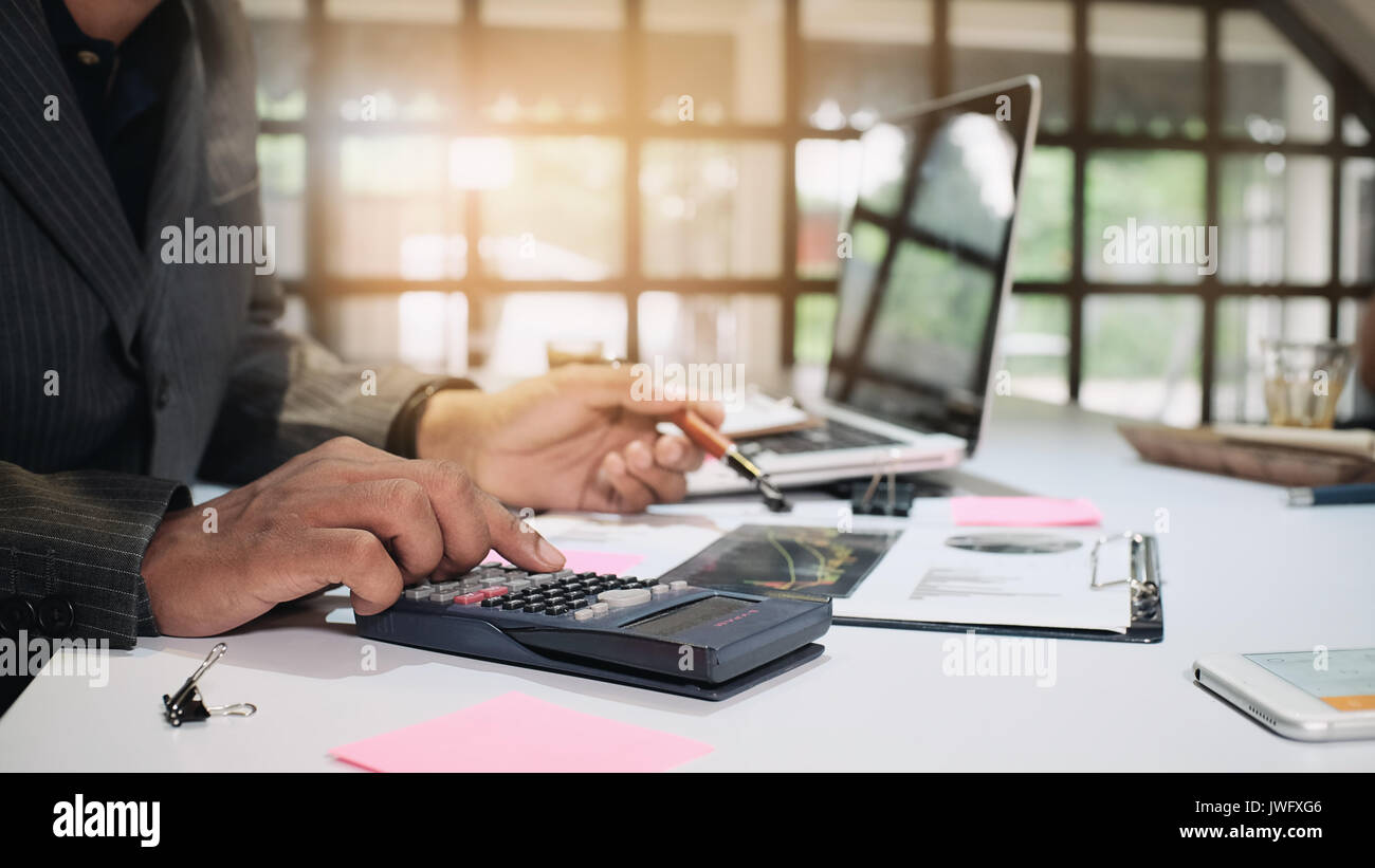 Business mann Berechnung Finanzierung auf Rechner in einem Büro im 16:9 Format. Stockfoto