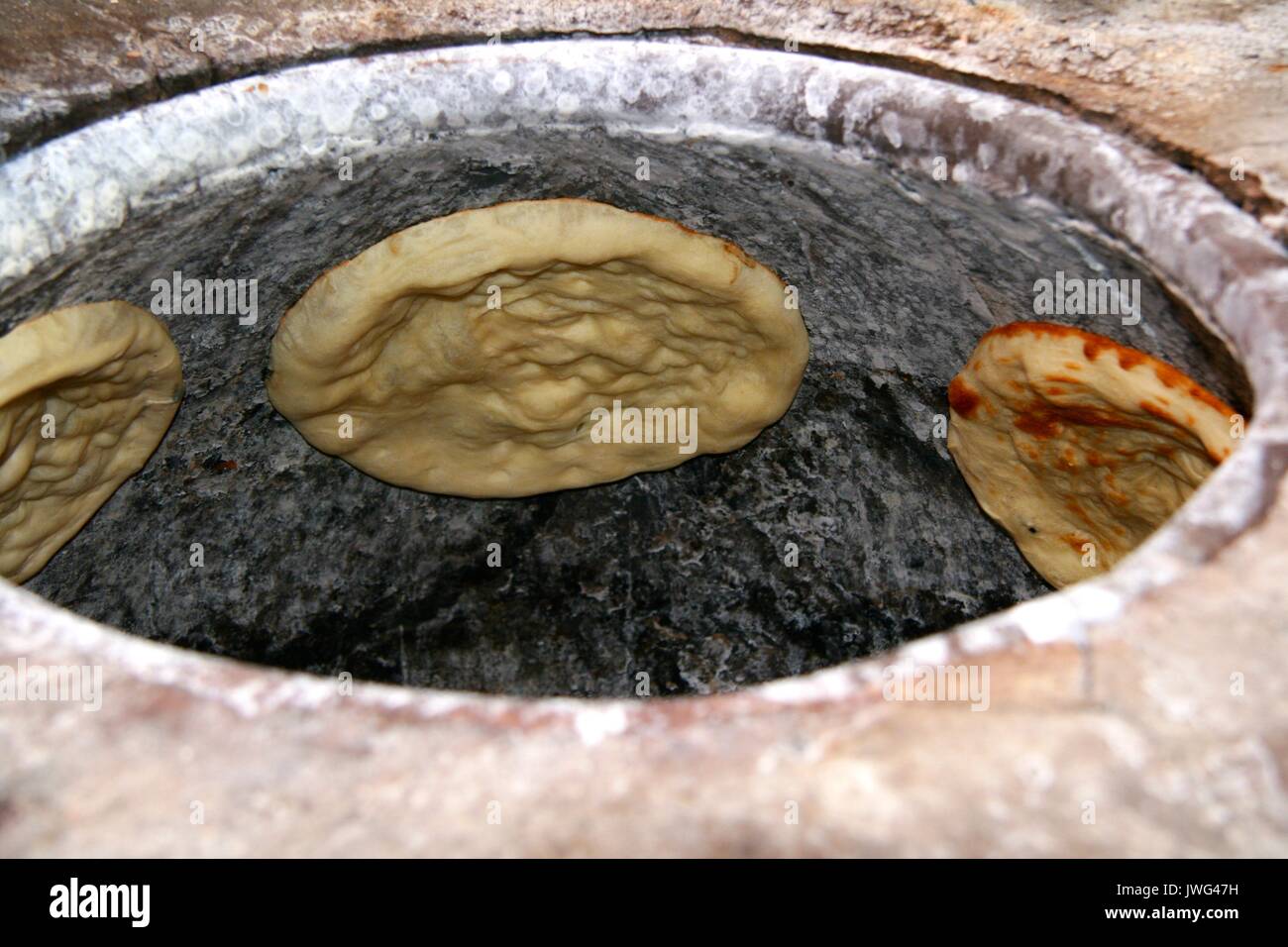 Naan Brot backen im Freien Backofen in Kashgar Stockfoto